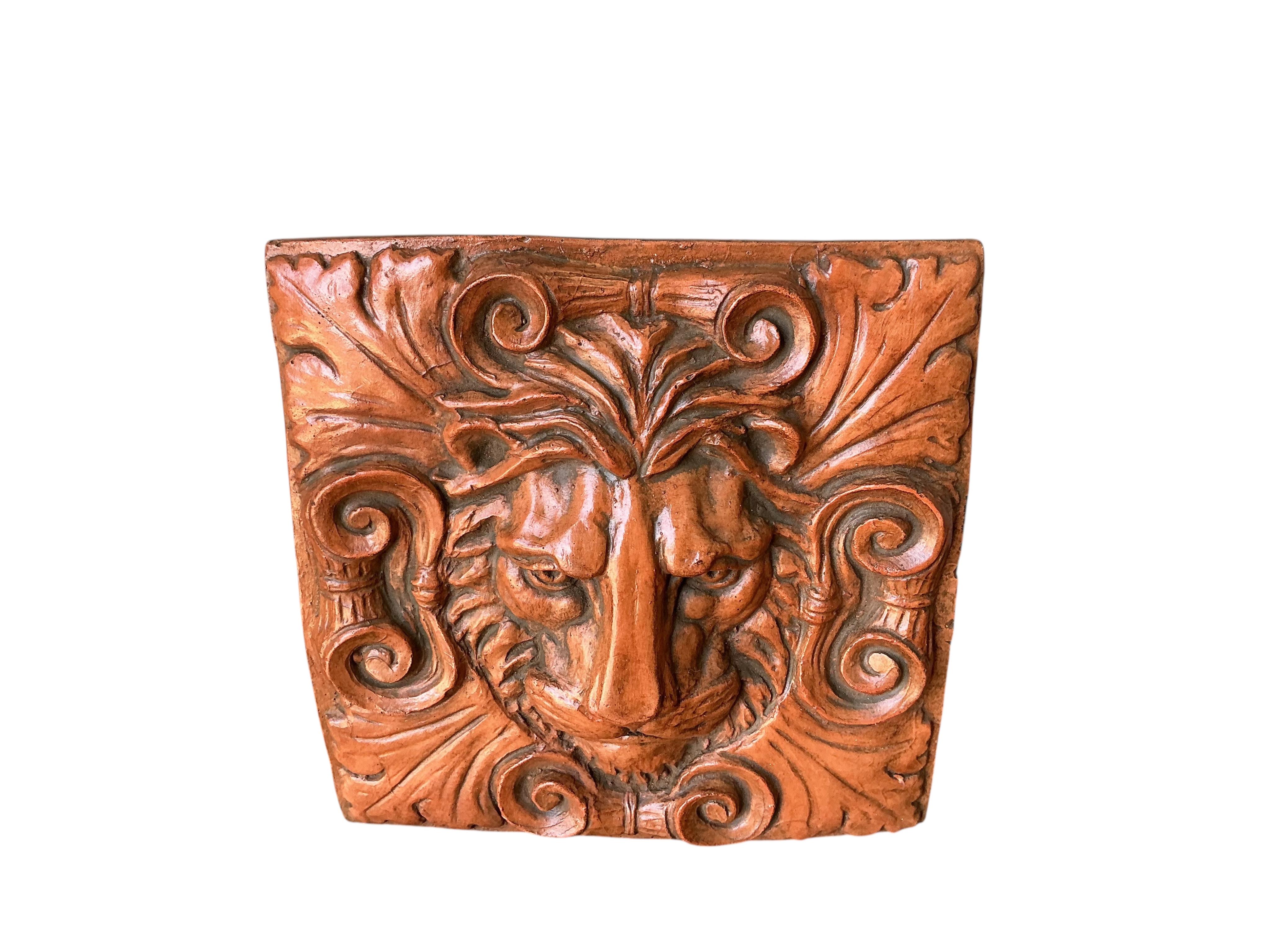 A terracotta lion mask garden wall tile, width 29cm, height 30cm
